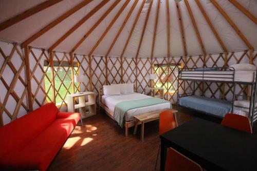 a room with two beds and a couch in a yurt at Yosemite RV Resort in Coarsegold