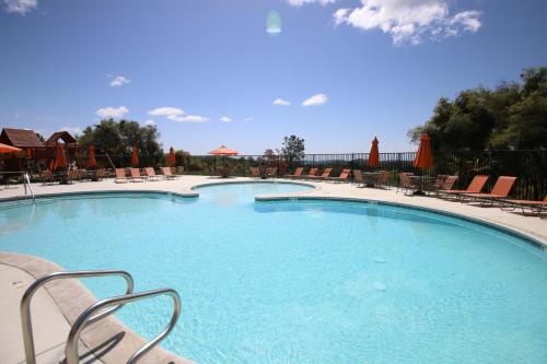 a large swimming pool with chairs and umbrellas at Yosemite RV Resort in Coarsegold