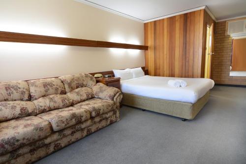 a living room with a couch and a bed at City Centre Motel in Bendigo