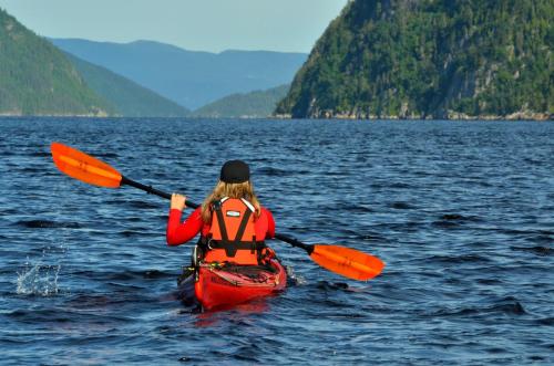 a woman in a kayak on a body of water at Centre de Vacances 5 Étoiles Family Resort in Sacré-Coeur-Saguenay