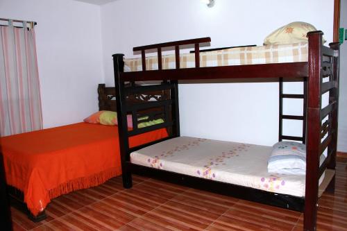 サンタ・マルタにあるAparta Hotel Palaciosの二段ベッド2組(オレンジ色のベッド1台付)