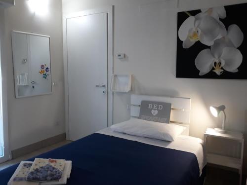 Un dormitorio con una cama azul y blanca y un espejo en La Casa Di Emma, en Rozzano