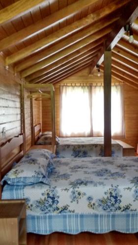 a bedroom with a bed in a wooden house at CASA TEMPORADA SANTO ANTONIO in Urubici