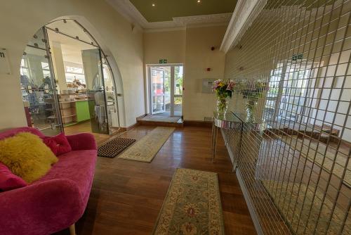 a living room with a pink couch and a mirror at Villa Mentone Hotel in Shanklin