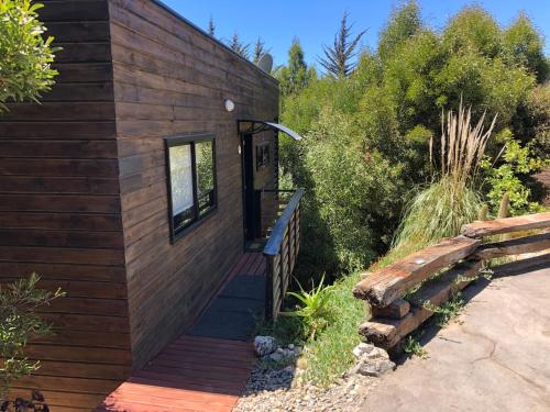 a wooden cabin with a wooden walkway leading to the door at Cabaña del Bosque in Pichilemu