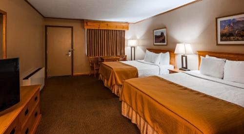 a hotel room with two beds and a flat screen tv at Deadwood Miners Hotel & Restaurant in Deadwood