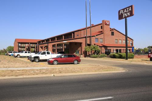 a red car parked in front of a brick building at Plaza Inn Midland in Midland