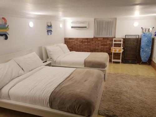 una camera con due letti e un divano in camera di One Bedroom Chalet managed by Lilly Apartments a Hurghada