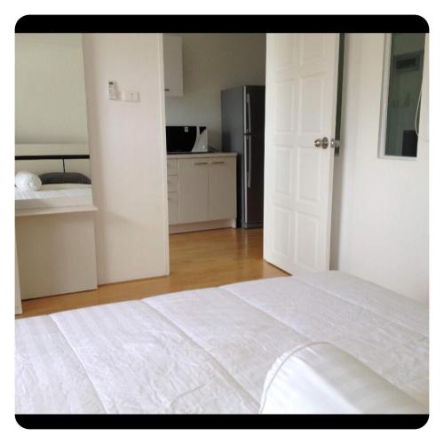 una camera bianca con letto bianco e cucina di Apartment in Ranghill Residence Phuket a Phuket