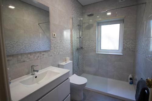 a bathroom with a sink and a toilet and a shower at 70s House by Capicua in Braga