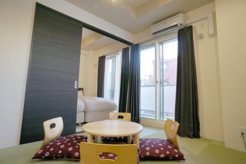 una habitación con mesa y sillas y un dormitorio en momo premium 403, en Sapporo
