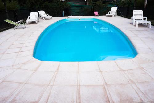 een groot blauw zwembad met stoelen op een patio bij Complejo Los Olivos in San Rafael