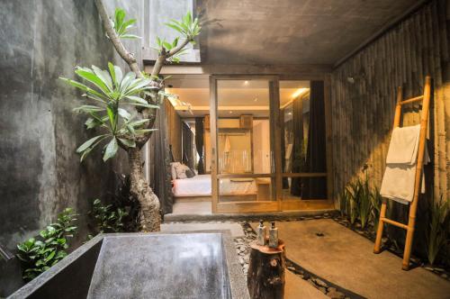 a room with a bathroom with a tree in it at The Tiing Tejakula Villas in Tejakula