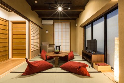 ein Wohnzimmer mit roten Kissen und einem Tisch in der Unterkunft No.10 Kyoto House in Kyoto