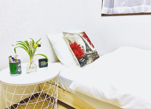 a bed with a table and a pillow on it at Alo BnB 3 - Near KOMAGOME, IKEBUKURO, SHINJUKU, UENO - MAX 16 PAX in Tokyo