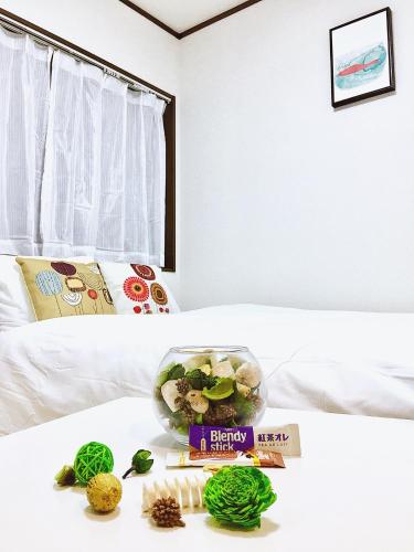 a table with a bowl of food on a bed at Alo BnB 3 - Near KOMAGOME, IKEBUKURO, SHINJUKU, UENO - MAX 16 PAX in Tokyo