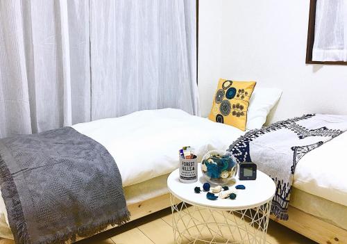 a room with a bed and a table next to a bed at Alo BnB 3 - Near KOMAGOME, IKEBUKURO, SHINJUKU, UENO - MAX 16 PAX in Tokyo