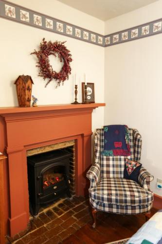 a living room with a fireplace and a chair at Deer Creek Winery at Watson Estate in Uniontown
