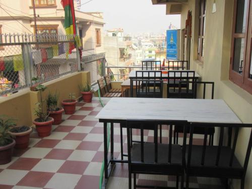 a room with tables and chairs on a checkered floor at STUPA VIEW INN in Kathmandu