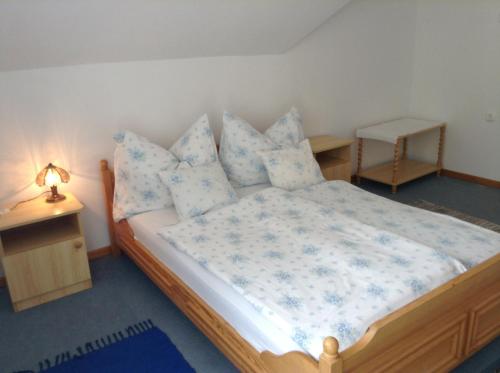 Un dormitorio con una cama con sábanas y almohadas azules y blancas en Vili Apartmanház, en Keszthely
