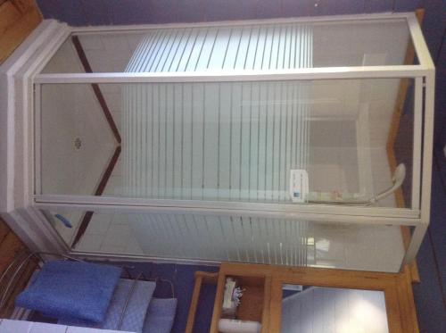 a glass shelf with a table in a room at Gîte Au Coin De La Berge in Perce