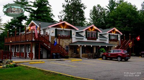 a building with a car parked in a parking lot at Edgewater Inn & Cottages in Eagle River