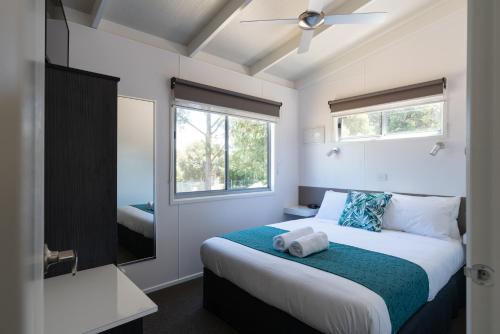 a bedroom with a large bed and a window at BIG4 Castlemaine Gardens in Castlemaine