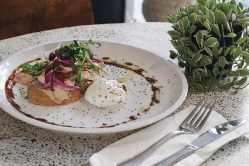 a plate of food on a table next to a fork and knife at Lloyd's Inn Bali in Seminyak