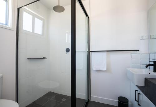 a glass shower door in a bathroom with a sink at BIG4 Castlemaine Gardens in Castlemaine