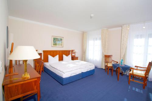a bedroom with a bed and a table and chairs at Hotel Badehaus Goor in Putbus