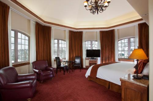 a hotel room with a bed and a desk and chairs at Tivoli Lodge in Vail