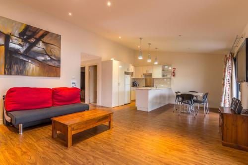 a living room with a red couch and a table at Wollongong Surf Leisure Resort in Wollongong
