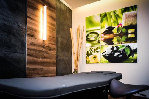 a black bench in a room with a picture on the wall at Ruben Hotel Zielona Góra in Zielona Góra