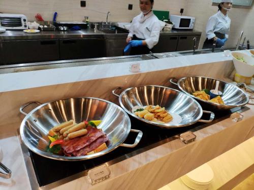 three bowls of food on a counter in a kitchen at Wyndham Grand Maoming in Maoming