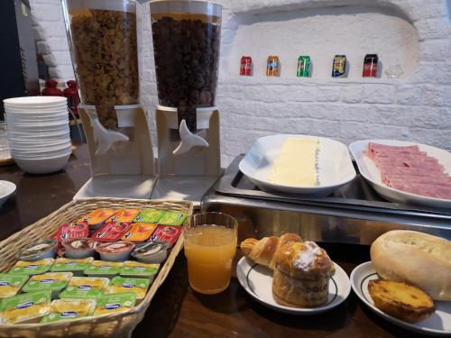 a buffet with bread and pastries and orange juice at Hotel Nazareth in Lisbon