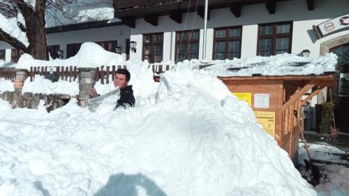 a man is standing in a pile of snow at Pension Oberwirt in Fischbachau