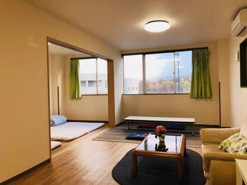 a living room with a couch and a table at Mikawa House Osaka Castle in Osaka