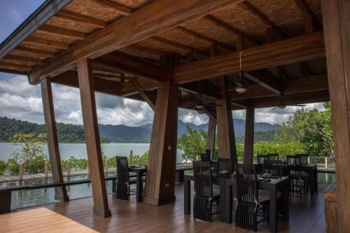 a restaurant with tables and chairs and a view of the water at Parama Koh Chang in Ko Chang