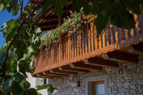 a wooden balcony with plants on the side of a building at Casa Krajnova in Oblizza