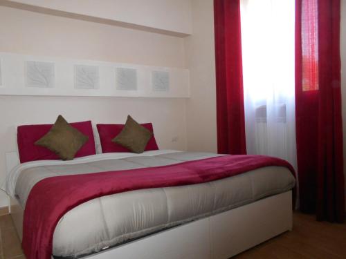 a bedroom with a large bed with red pillows at I Tre Laghi Countryhouse 14 posti letti Cottage 10 posti letti in Citta' Sant'Angelo