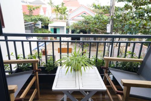 a white table with a plant on a balcony at Le Printemps d' An Bang in Hoi An