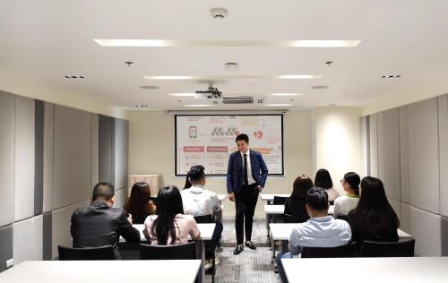 a man giving a presentation in front of a group of people at Hop Inn Hotel Tomas Morato Quezon City in Manila