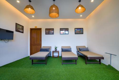 a waiting room with two benches and a tv at Le Printemps d' An Bang in Hoi An