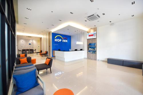 a hore inn lobby with chairs and a large sign at Hop Inn Hotel Tomas Morato Quezon City in Manila
