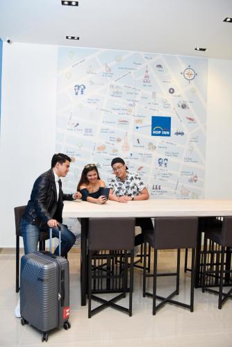 a group of people sitting at a table with a wall at Hop Inn Hotel Tomas Morato Quezon City in Manila