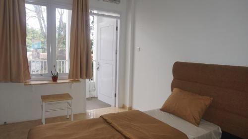 a bedroom with a bed and a window at Al Barra Syariah Hotel in Bukittinggi