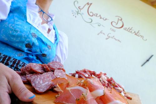 a person holding a cutting board with food on it at La Roccia Wellness Hotel in Cavalese