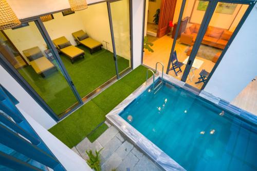 an indoor swimming pool in a house with a yard at Le Printemps d' An Bang in Hoi An