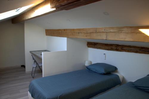 - une chambre avec un lit bleu et un bureau dans l'établissement Mas Du Petit Claux, à Barbentane