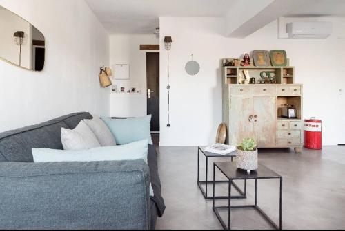 a living room with a blue couch and a table at Le 40 in LʼIsle-sur-la-Sorgue